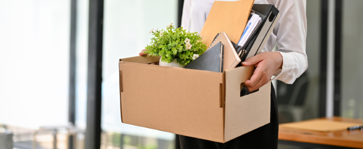 woman carrying a box after being terminated at work